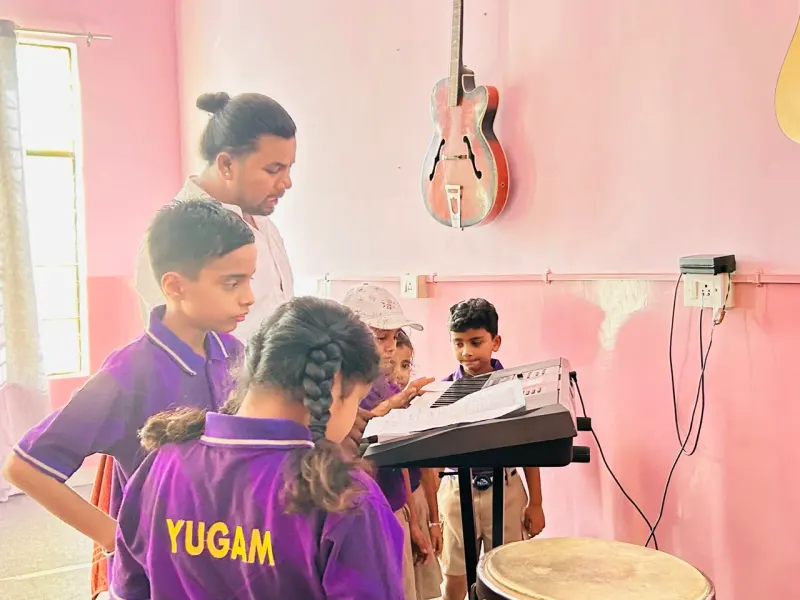 Student in Yugam uniform learning the keyboard