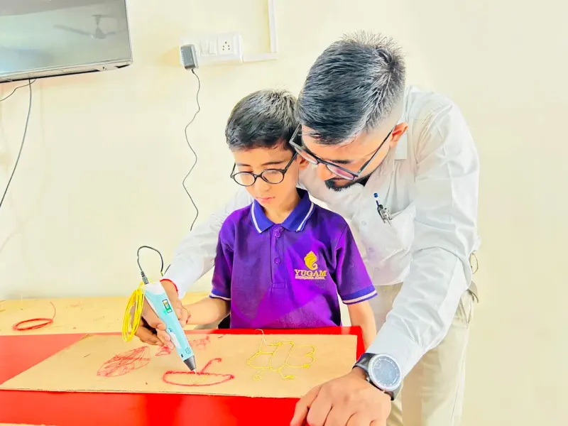Mentor guiding a young innovator at the robotics lab